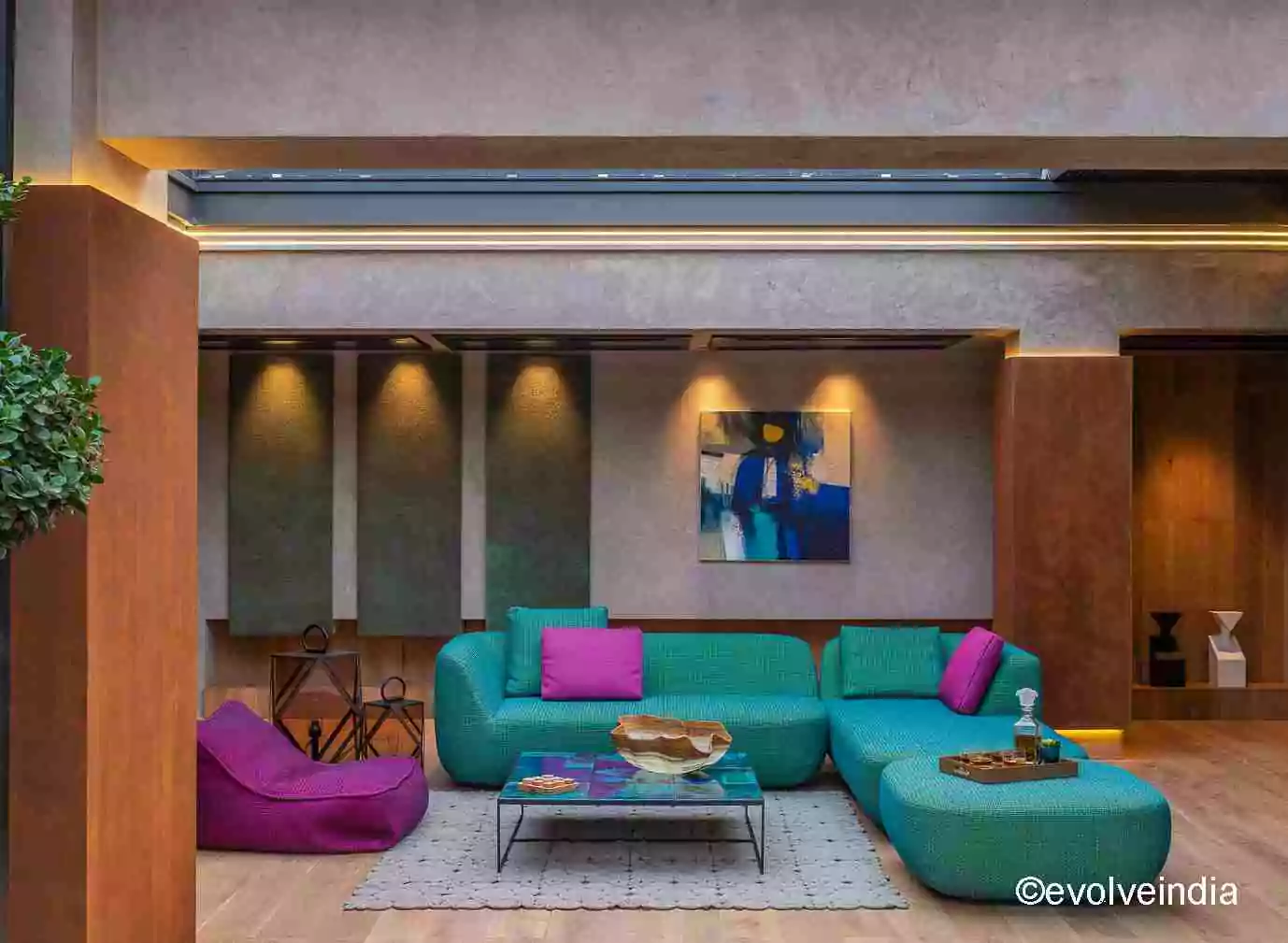 Seamless wall designed using textured concrete, liquid metal and corten steel finishes by Evolve India